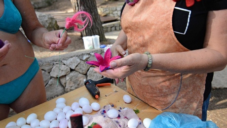 Two people crafting with colorful materials and foam eggs
