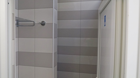 Tiled shower area with a towel rack