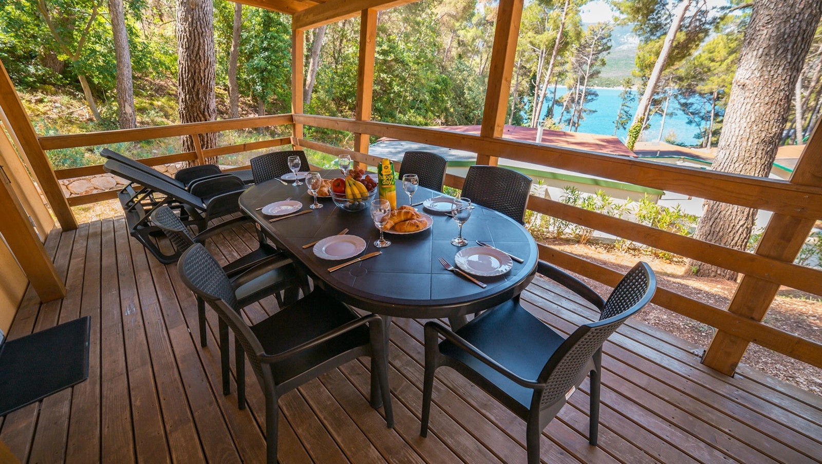 Dining area on a wooden deck with a view of the sea in Bijar