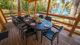 Dining area on a wooden deck with a view of the sea in Bijar